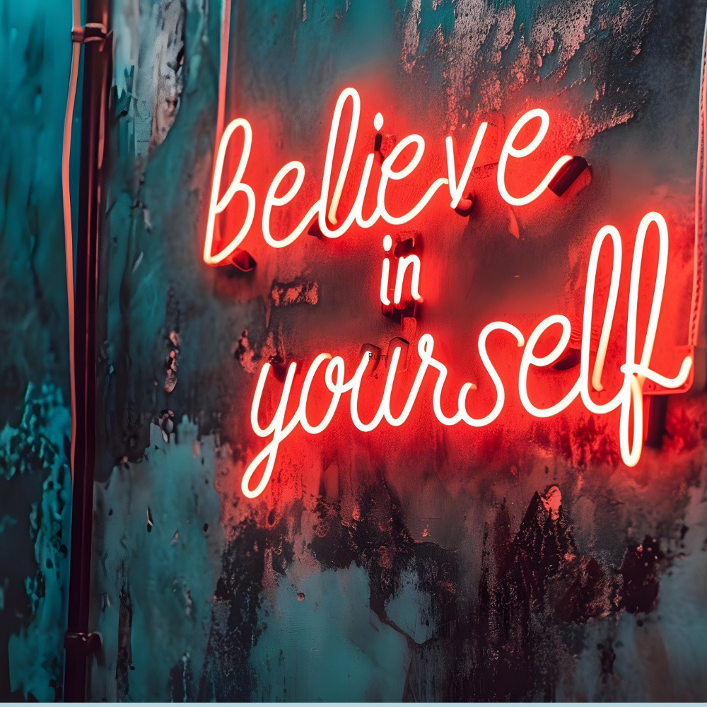 Red neon sign glowing with the words “Believe in yourself” on a textured wall, symbolising empowerment and self-trust.
