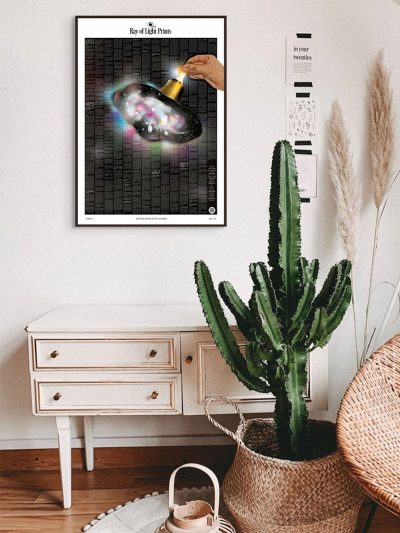 Framed Evolution of the Universe print (Dark Edition) on a wall in a minimalist room with cactus décor.